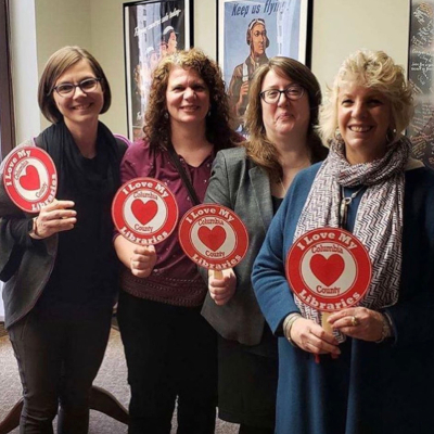 4 women holding "I Love My Libraries" signs